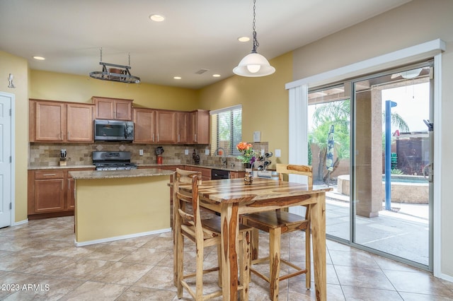 kitchen with decorative light fixtures, stainless steel appliances, decorative backsplash, and light tile patterned flooring