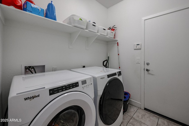 laundry room featuring light tile patterned floors and washer and clothes dryer