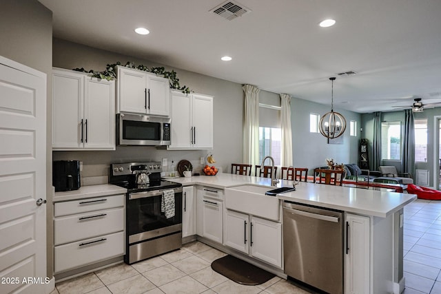 kitchen with white cabinetry, stainless steel appliances, kitchen peninsula, and sink