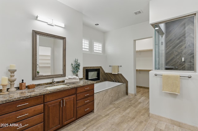6146 E Dixileta Dr, Cave Creek, AZ 85331 - full bathroom featuring a garden tub, visible vents, wood finished floors, vanity, and a spacious closet