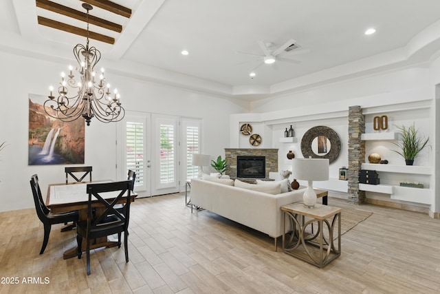 6146 E Dixileta Dr, Cave Creek, AZ 85331 - living room with a fireplace, light wood-style floors, ceiling fan with notable chandelier, recessed lighting, and a tray ceiling