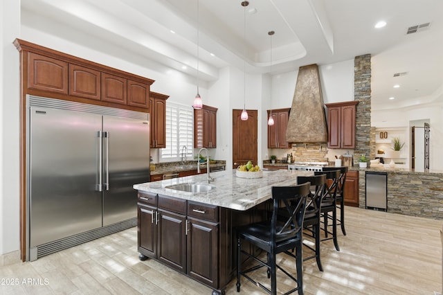 6146 E Dixileta Dr, Cave Creek, AZ 85331 - kitchen with a tray ceiling, decorative backsplash, built in refrigerator, visible vents, and custom exhaust hood