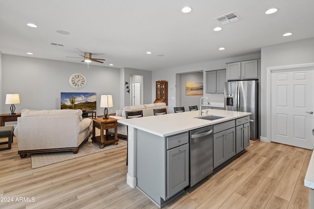 kitchen featuring gray cabinets, stainless steel appliances, light wood-type flooring, and sink