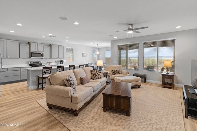 living room featuring light wood-type flooring and ceiling fan