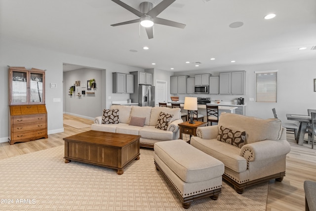 living room with ceiling fan and light wood-type flooring