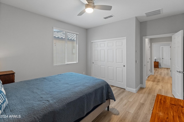 bedroom with light hardwood / wood-style floors, ceiling fan, and a closet