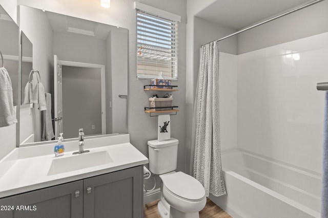 full bathroom featuring wood-type flooring, vanity, shower / tub combo, and toilet