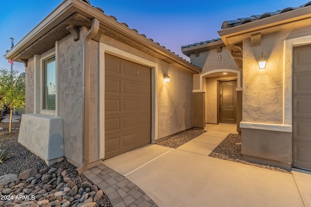 exterior entry at dusk with a garage