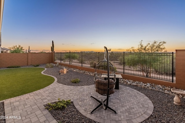 yard at dusk featuring a patio