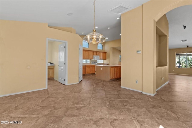 kitchen with visible vents, baseboards, light countertops, arched walkways, and a notable chandelier