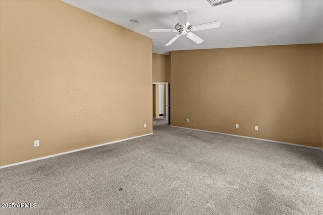 empty room with carpet flooring, a ceiling fan, and baseboards