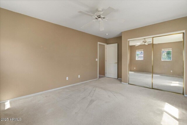 unfurnished bedroom with a ceiling fan, baseboards, carpet, and a closet