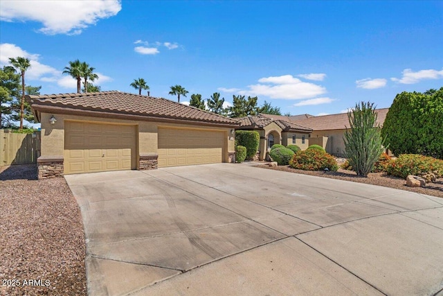 view of front of house with fence, a tile roof, stone siding, stucco siding, and concrete driveway