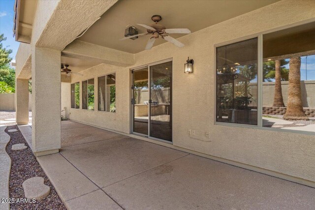 view of patio with ceiling fan and fence