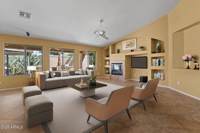 tiled living room with baseboards, a ceiling fan, built in shelves, and visible vents