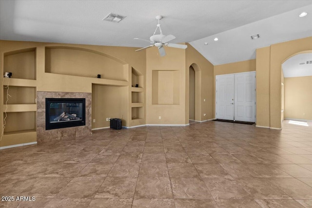 unfurnished living room featuring visible vents, built in features, ceiling fan, and baseboards