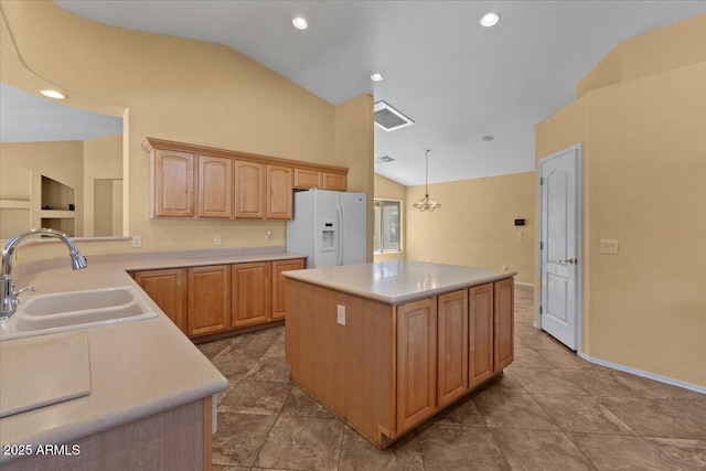 kitchen featuring visible vents, lofted ceiling, light countertops, a sink, and white fridge with ice dispenser
