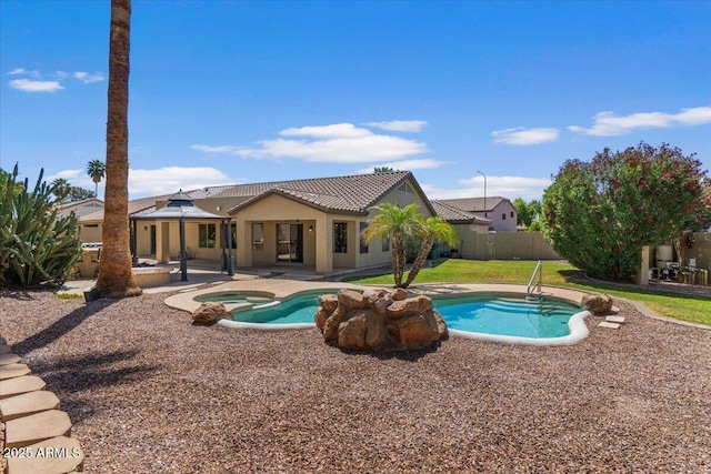 view of pool featuring a patio, fence, and a pool with connected hot tub