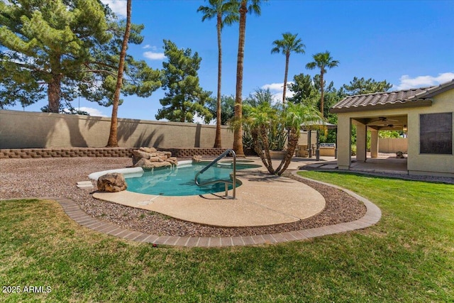 view of swimming pool featuring a jacuzzi, a fenced backyard, a lawn, a ceiling fan, and a patio
