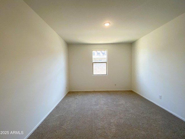 carpeted empty room featuring baseboards