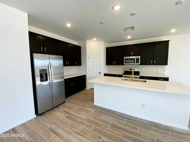 kitchen featuring visible vents, light countertops, recessed lighting, wood finish floors, and stainless steel appliances
