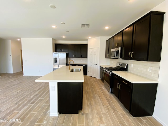 kitchen with a sink, visible vents, appliances with stainless steel finishes, and wood finish floors