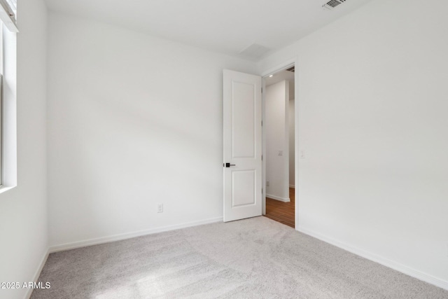 spare room featuring carpet floors, baseboards, and visible vents