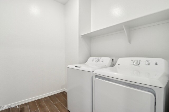 washroom featuring wood finish floors, separate washer and dryer, laundry area, and baseboards