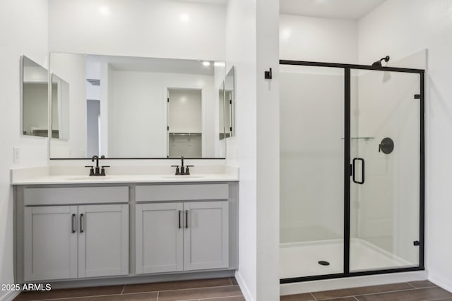 bathroom featuring a shower stall, a sink, and wood tiled floor