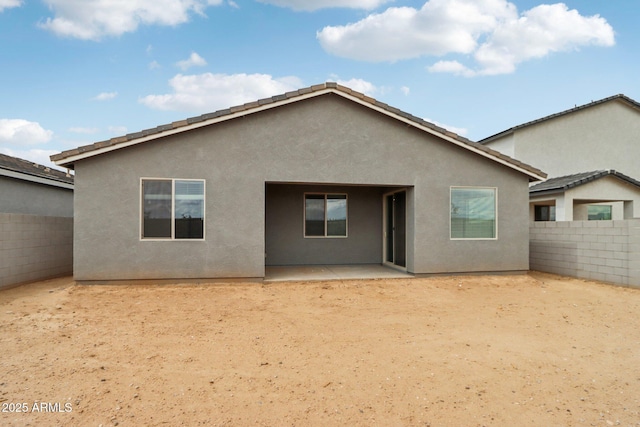 rear view of house with a patio area, a fenced backyard, a tiled roof, and stucco siding