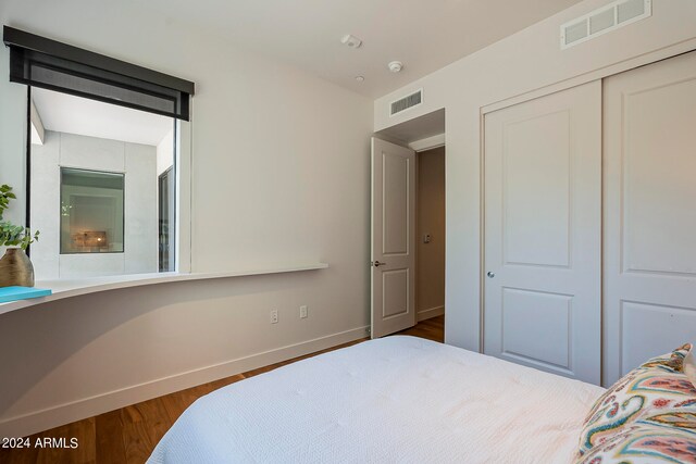 bedroom featuring dark hardwood / wood-style floors and a closet