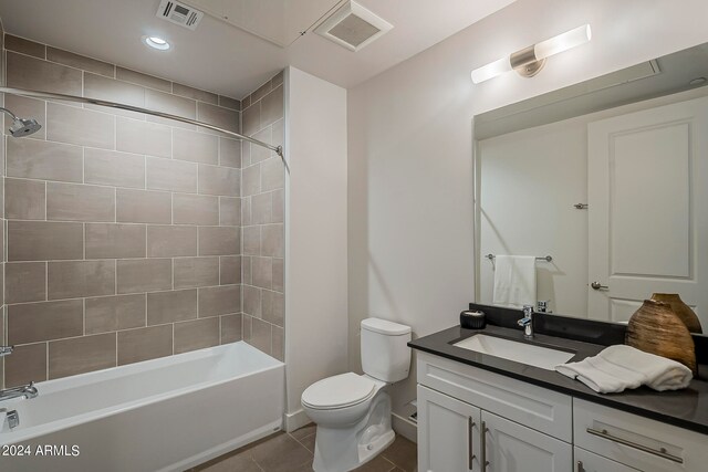 full bathroom featuring tiled shower / bath combo, toilet, tile floors, and vanity with extensive cabinet space