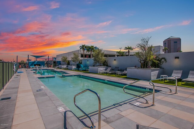 pool at dusk with a patio