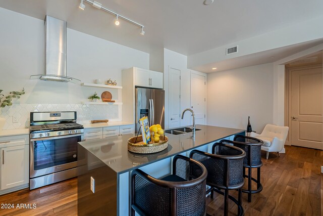 kitchen featuring dark hardwood / wood-style floors, sink, appliances with stainless steel finishes, backsplash, and wall chimney range hood