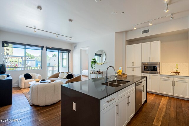 kitchen with white cabinetry, sink, stainless steel appliances, a center island with sink, and rail lighting