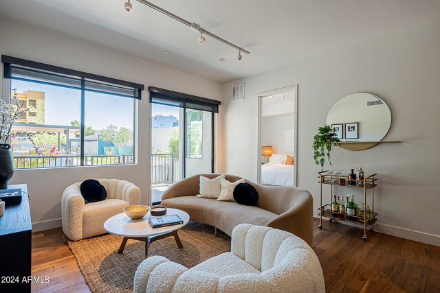 living room with dark hardwood / wood-style flooring and track lighting