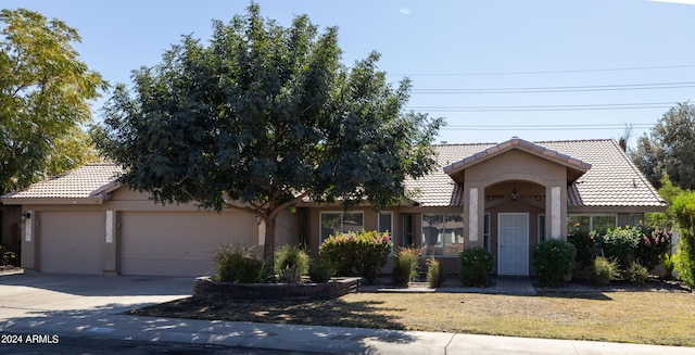 view of front of home with a front yard and a garage