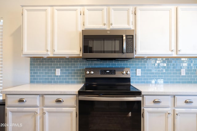 kitchen featuring appliances with stainless steel finishes, white cabinets, and tasteful backsplash