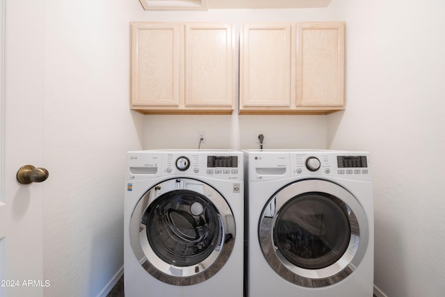 laundry area with cabinets and washer and clothes dryer