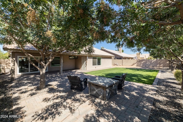 back of property featuring a patio and a yard