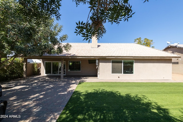 rear view of property featuring a patio and a yard