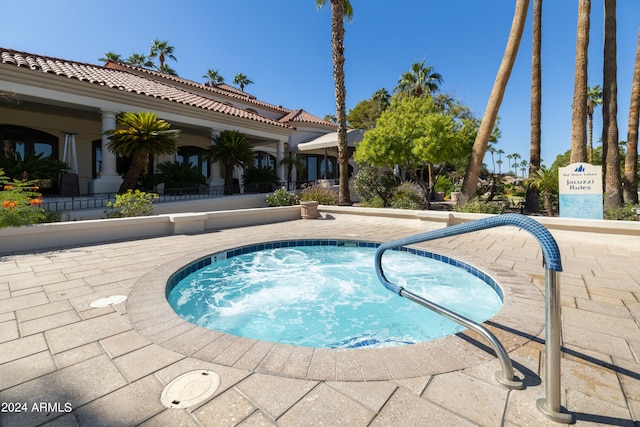 view of swimming pool featuring a hot tub and a patio