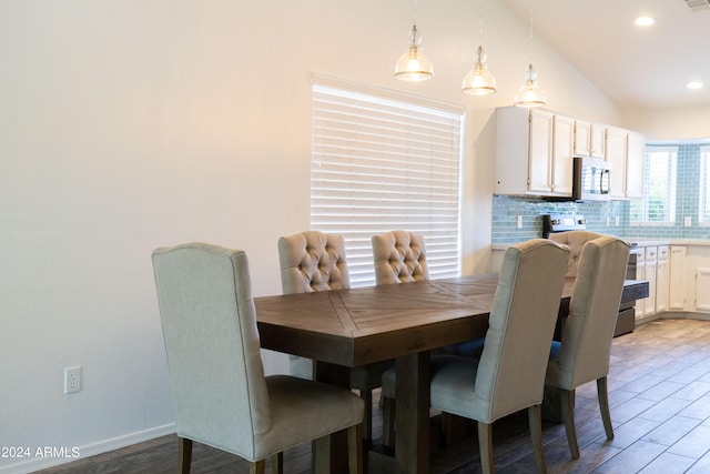 dining area featuring light hardwood / wood-style floors and vaulted ceiling