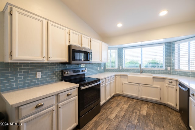 kitchen featuring decorative backsplash, dark hardwood / wood-style flooring, vaulted ceiling, sink, and stainless steel appliances