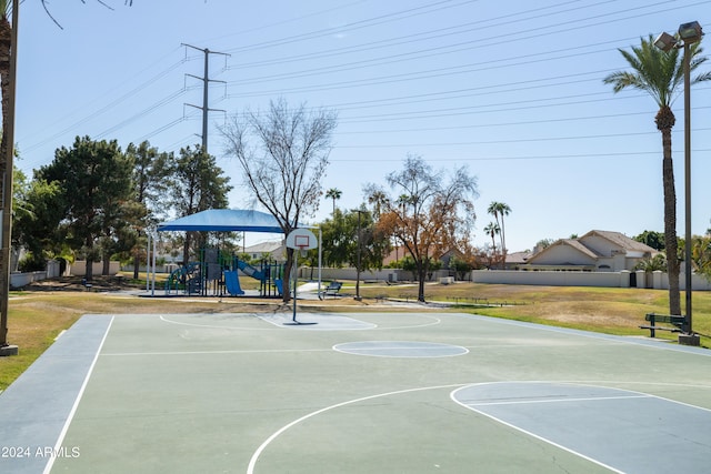 view of sport court with a playground and a yard