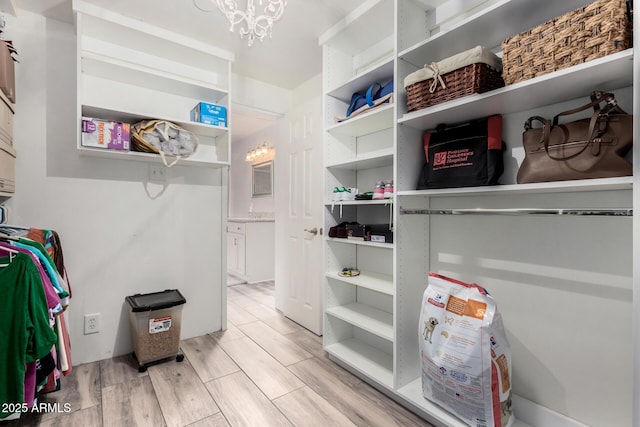 walk in closet featuring an inviting chandelier