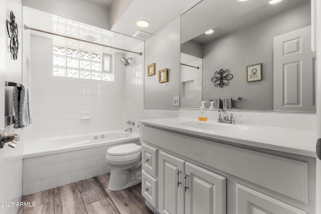 full bathroom featuring vanity, hardwood / wood-style floors, toilet, and tiled shower / bath