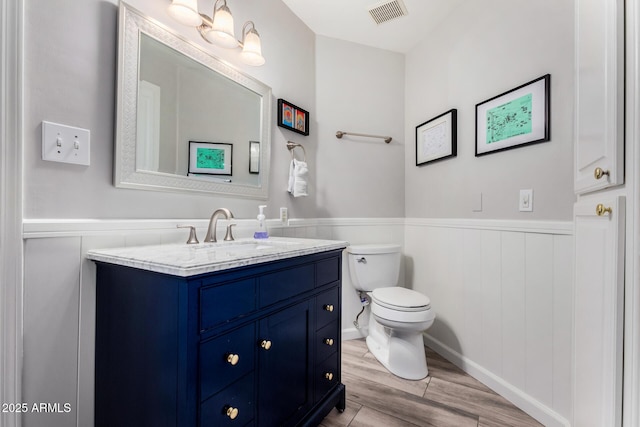 bathroom with wood-type flooring, vanity, and toilet