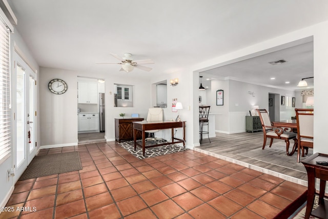 living room featuring ceiling fan, ornamental molding, and dark tile patterned floors