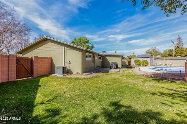 rear view of property with an empty pool, a patio area, central AC, and a lawn